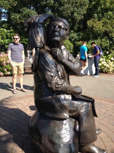 A statue of Emily Carr that makes her look like an unattractive man...that is a monkey on her shoulder.